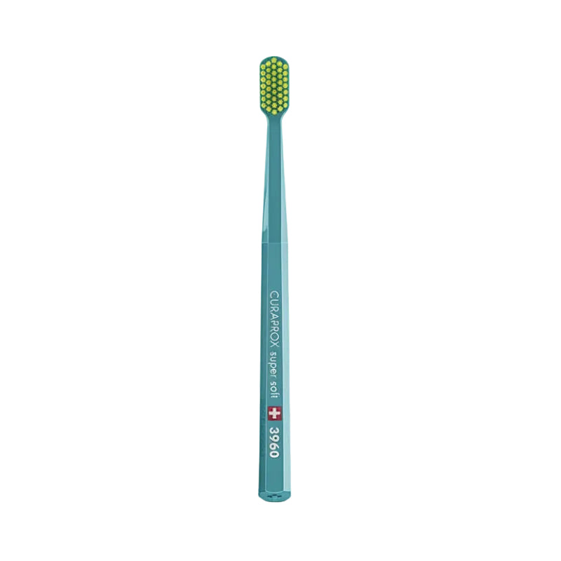 A Curaprox CS 3960 Super Soft toothbrush with green and yellow bristles on a teal handle.