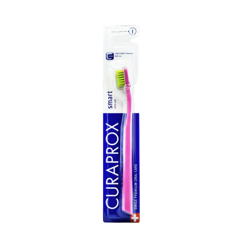 Packaged Curaprox Smart Ultra Soft toothbrush with pink handle and green and white bristles.