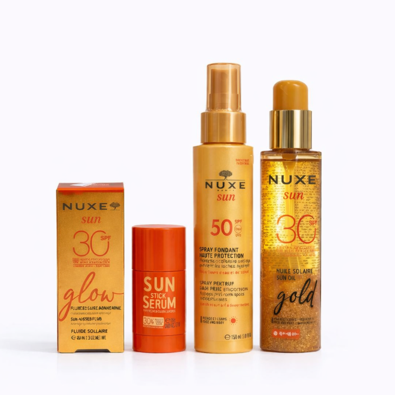Nuxe sun care products including a box, serum, and oil on a white background