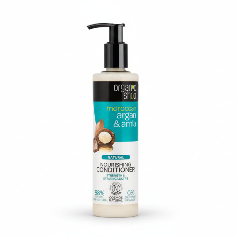 A bottle of Organic Shop Morocoo Argan & Amla nourishing conditioner with a pump dispenser, predominantly white label with green and brown accents and an image of a coconut.
