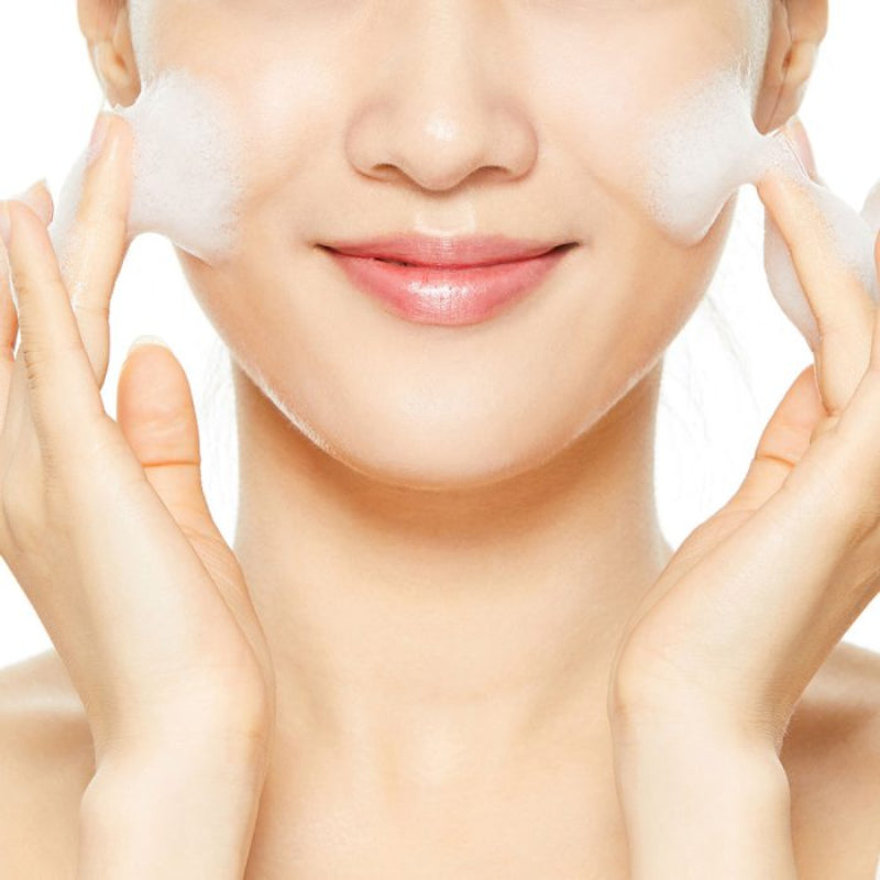 Woman applying a facial mask with a white background