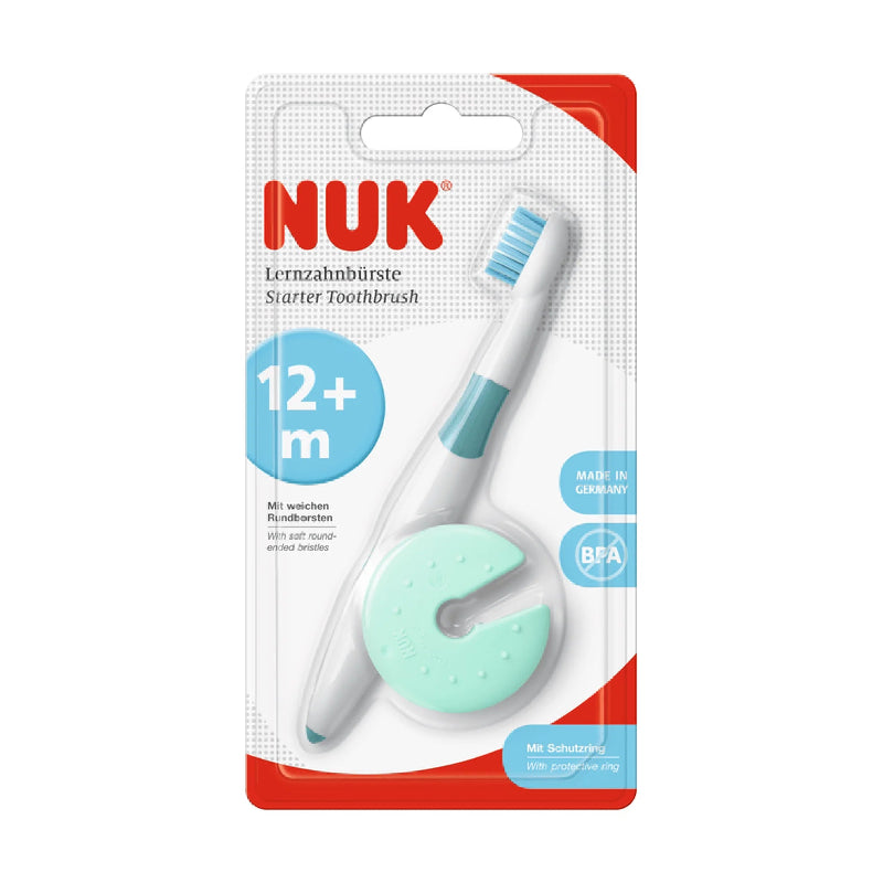 A packaged NUK brand baby toothbrush and training toothpaste set, labeled for 12+ months, predominantly white and blue color.